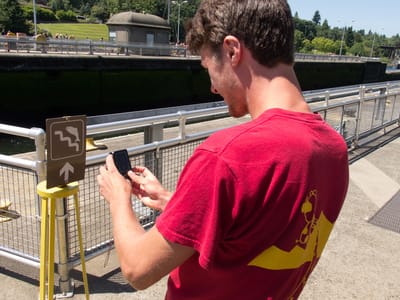 Seattle: Tom Photographing Jumping Salmon Sign at Chittenden Locks