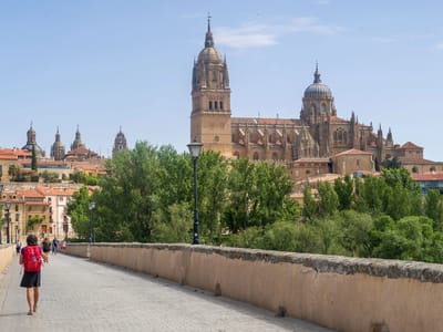 Salamanca: Lolo walking across the Roman Bridge towards the Salamanca Cathedral