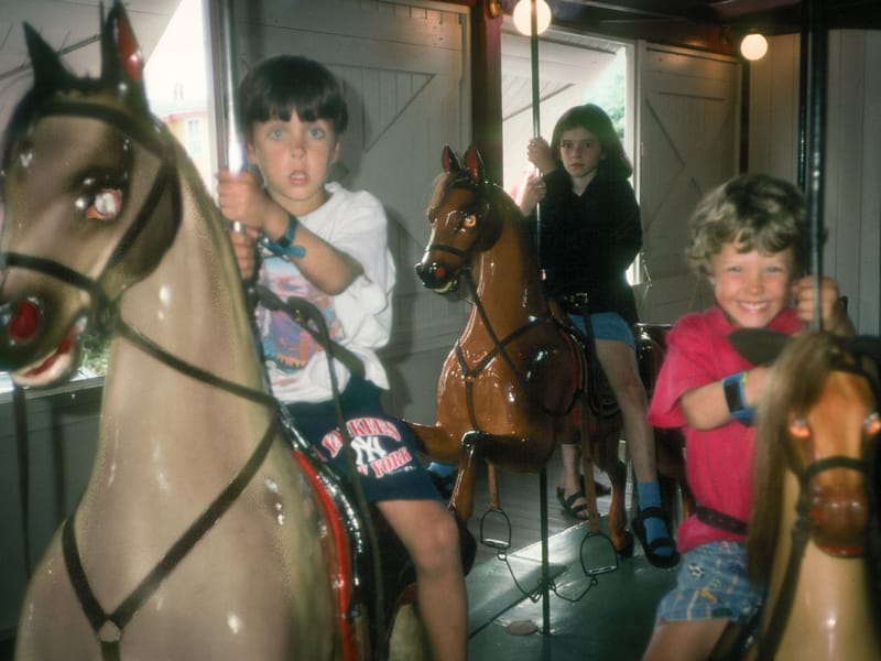 Andrew and Tommy riding Flying Horses Carousel