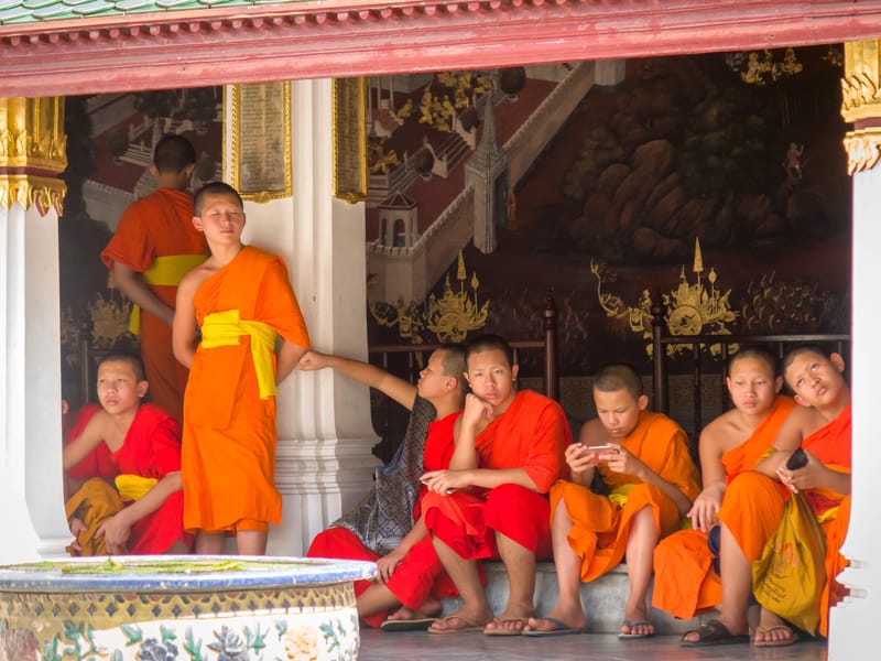 Young Buddhist monks playing with their material possessions