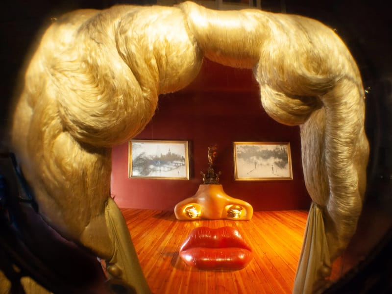 Mae West room with sofa lips, a fireplace nose, and two paintings for her eyes.